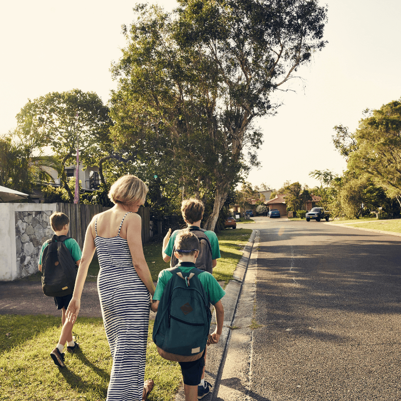 A mother walking three boys to school